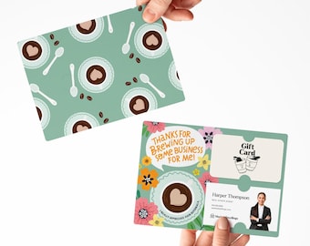 May include: A green and white gift card with a coffee cup design and the text "Thanks for brewing up some business for me!" and "Really appreciate your referrals". The card also includes a gift card section with the text "Gift Card" and a business card with the name "Harper Thompson" and the text "Real Estate Agent".