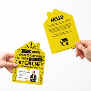 May include: Yellow house-shaped card with black text that reads "Top 10 Things You Need To Do When Selling Your Home #1 Call Me (I'll handle the other 9)". A photo of a woman is in the window of the house. The card is held in a hand.