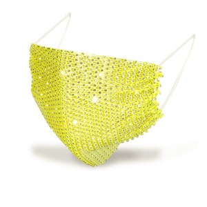 May include: A yellow face mask covered in rhinestones. The mask has a simple design and is made of a soft, flexible material.