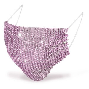May include: A pink face mask covered in rhinestones. The mask has elastic ear loops.