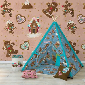 K&ouml;nnte beinhalten: Ein blaues und wei&szlig;es Lebkuchen-Tipi-Zelt mit einem braunen und wei&szlig;en Kissen und einem rosa und wei&szlig;en Kissen. Das Tipi ist in einem Raum mit einer rosa und goldenen Tapete mit Lebkuchen, einem Lebkuchenhaus und einem Lebkuchenberg aufgebaut.
