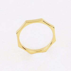 May include: A gold-toned ring with a geometric, octagonal design.
