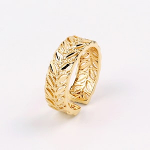 Könnte beinhalten: Ein verstellbarer Ring in Goldton mit einem Blattdesign.