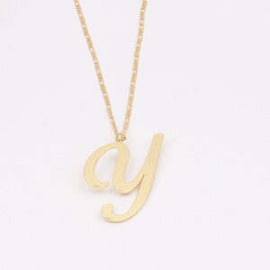 May include: A gold chain necklace with a cursive letter 'y' pendant.