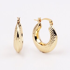 以下が含まれることがあります： 表面がテクスチャ加工されたゴールドのフープイヤリングのペア