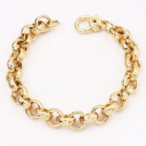 May include: A gold chain bracelet with a textured finish. The bracelet has a lobster clasp closure.