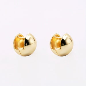 May include: A pair of gold hoop earrings. The earrings are round and have a smooth finish.