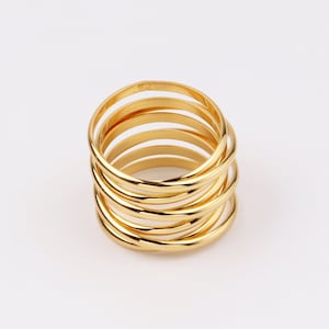 May include: A gold-toned ring made of multiple thin bands stacked on top of each other.