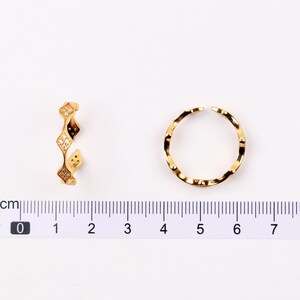 Puede incluir: Dos anillos de oro con un dise&ntilde;o texturizado. Un anillo tiene un dise&ntilde;o ondulado y el otro tiene un dise&ntilde;o en forma de diamante con piedras transparentes.