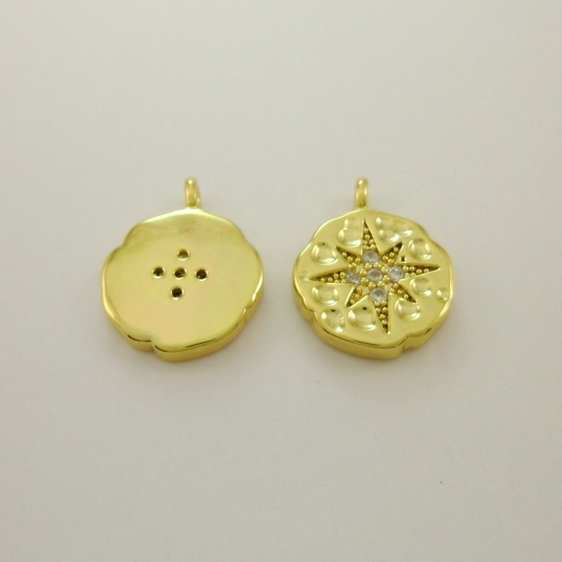 Pu&ograve; includere: Ciondolo pendente dorato con un design a stella con strass trasparenti. Il retro del ciondolo &egrave; liscio con una serie di piccoli fori.