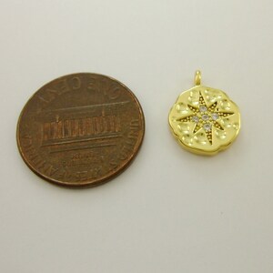 Pu&ograve; includere: Ciondolo pendente dorato con un design a stella e pietre di zircone cubico trasparenti. Il ciondolo &egrave; circa delle dimensioni di una moneta da un centesimo di euro.