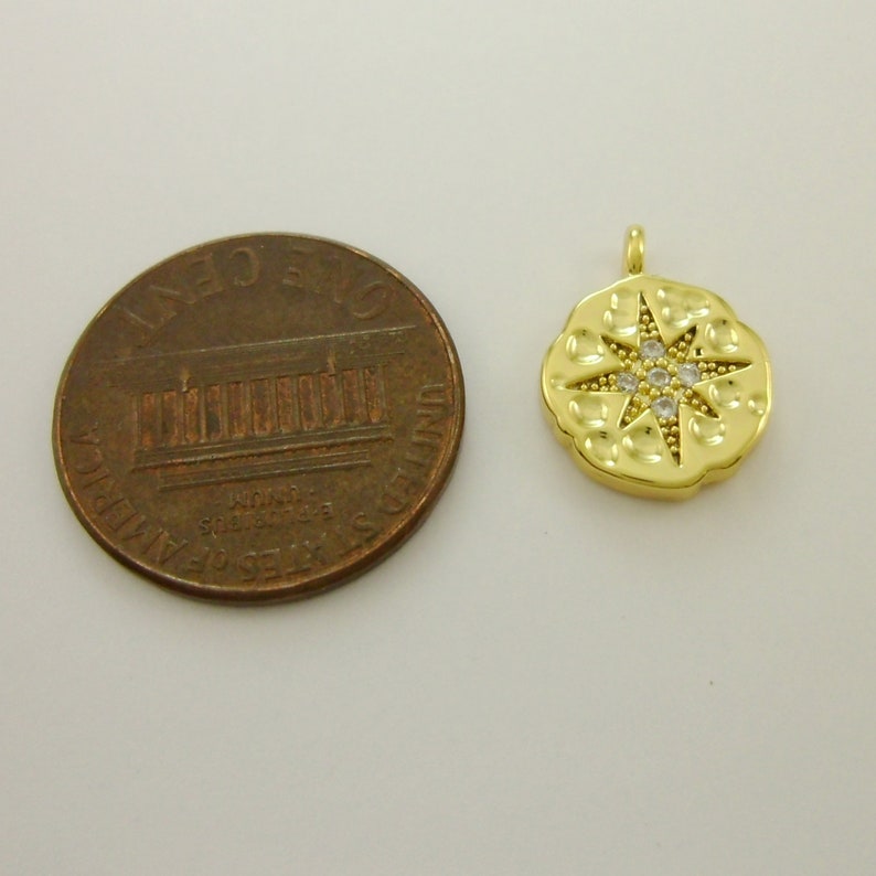 Pu&ograve; includere: Ciondolo pendente dorato con un design a stella e pietre di zircone cubico trasparenti. Il ciondolo &egrave; circa delle dimensioni di una moneta da un centesimo di euro.