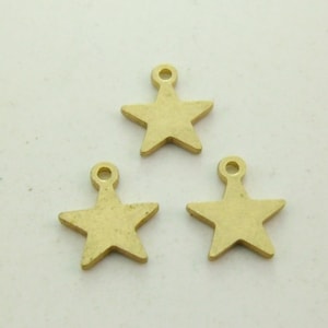 May include: Three gold-coloured metal star charms with a loop at the top for attaching to jewellery or crafts.