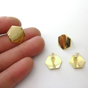 May include: Three gold hexagon shaped earrings with a post and butterfly backing.