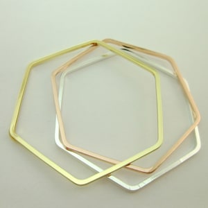 Puede incluir: Tres pulseras hexagonales en oro, oro rosa y plata.