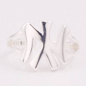 May include: A silver ring with a stylized letter 'N' design.
