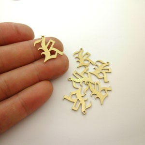 May include: A group of gold-colored metal charms shaped like the letter "K" in a gothic font. The charms have a hole at the top for attaching to a chain or bracelet.