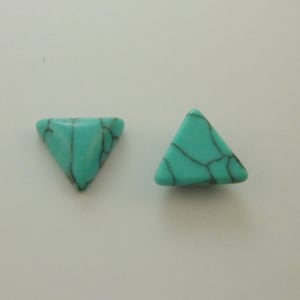 May include: Two turquoise triangle-shaped beads with a marbled pattern.
