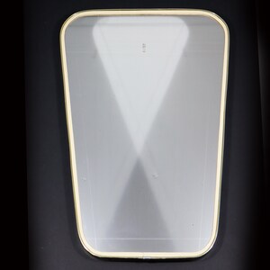 May include: A clear glass mirror with a gold-colored frame. The mirror has a slightly rounded shape and a beveled edge.