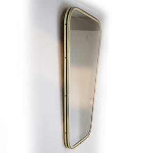 May include: A large, rectangular mirror with a cream-colored frame and black trim. The frame has a slightly rounded edge.