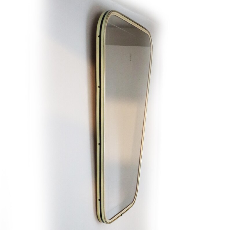 May include: A large, rectangular mirror with a cream-colored frame and black trim. The frame has a slightly rounded edge.