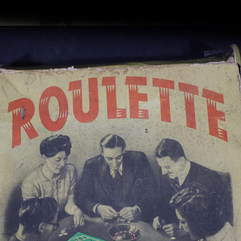 May include: A vintage cardboard game box featuring the word ROULETTE in large red letters. The box cover displays a black and white illustration of four people sitting around a table playing a game with a small roulette wheel and game chips.