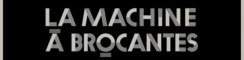 May include: A black rectangular sign featuring the text "LA MACHINE &Agrave; BROCANTES" in a stylized, art deco font. The text is in light grey, with the words stacked vertically. The background is black.