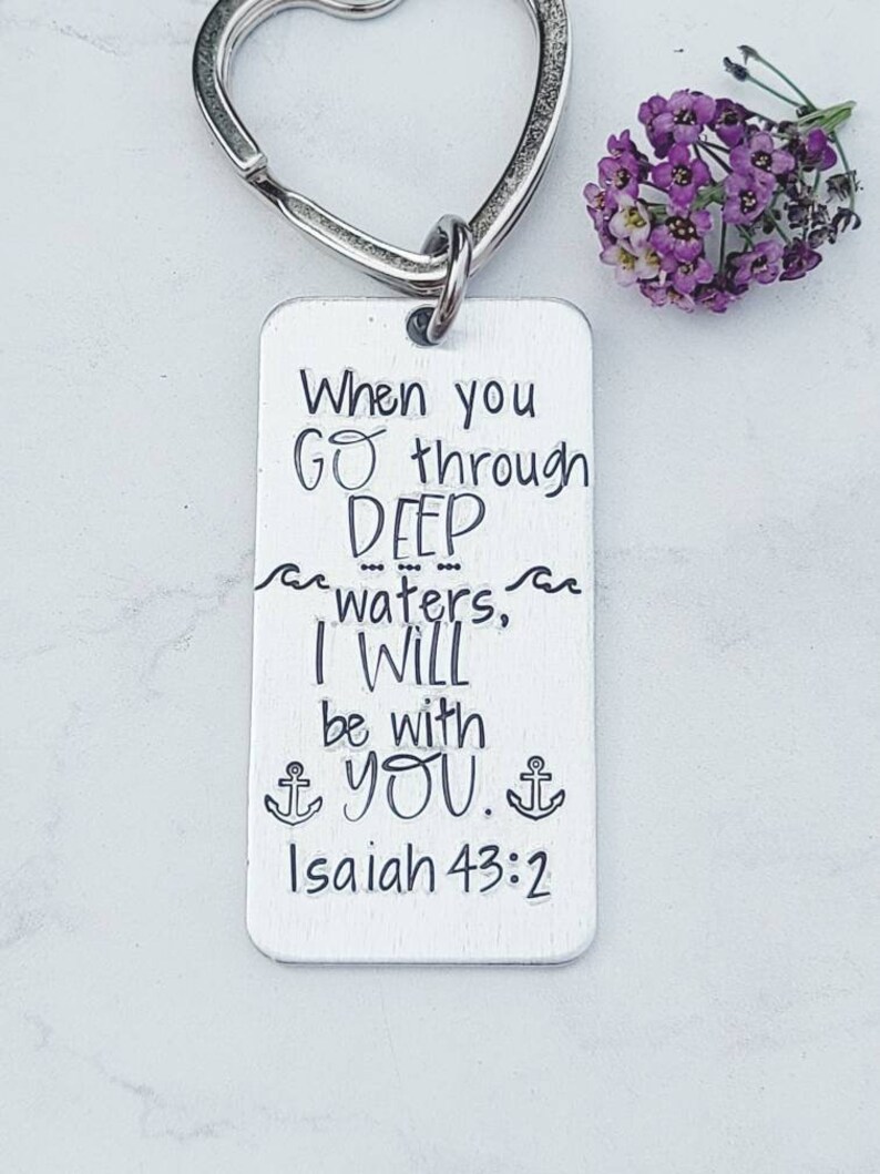 May include: Silver keychain with a heart-shaped ring and a rectangular tag. The tag has the text "When you go through DEEP waters, I WILL be with YOU. Isaiah 43:2" engraved on it.