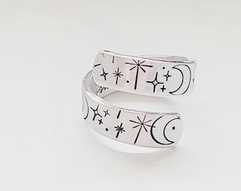 May include: A silver adjustable ring with a celestial design featuring moons and stars.