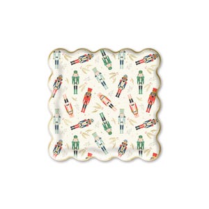 May include: White paper party plates with a scalloped edge and a gold trim. The plates feature a repeating pattern of nutcracker soldiers in red, green, and blue.