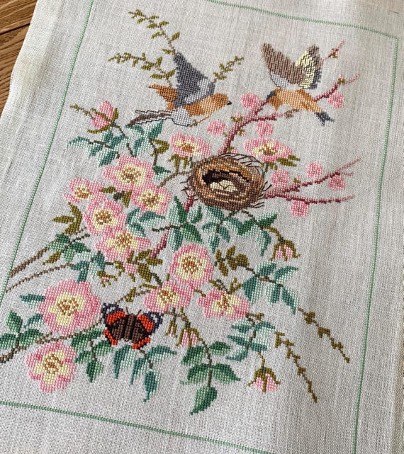 ピンクと緑の鳥と鳥の巣を描いたリネンのタペストリーに施された