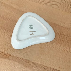 May include: A white triangular ceramic dish with a gold crown and the text "Carlha Bavaria" on the bottom.