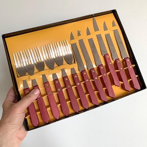 Oanvänt vintage bestickset för stek/grill med röda trähandtag och nitar. 6 gafflar, 6 knivar, 12 delar i originalkartong.
