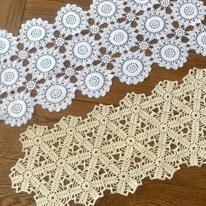 May include: Two crocheted doilies, one white and one beige, with intricate patterns. The white doily has a scalloped edge and a floral design. The beige doily has a geometric design.