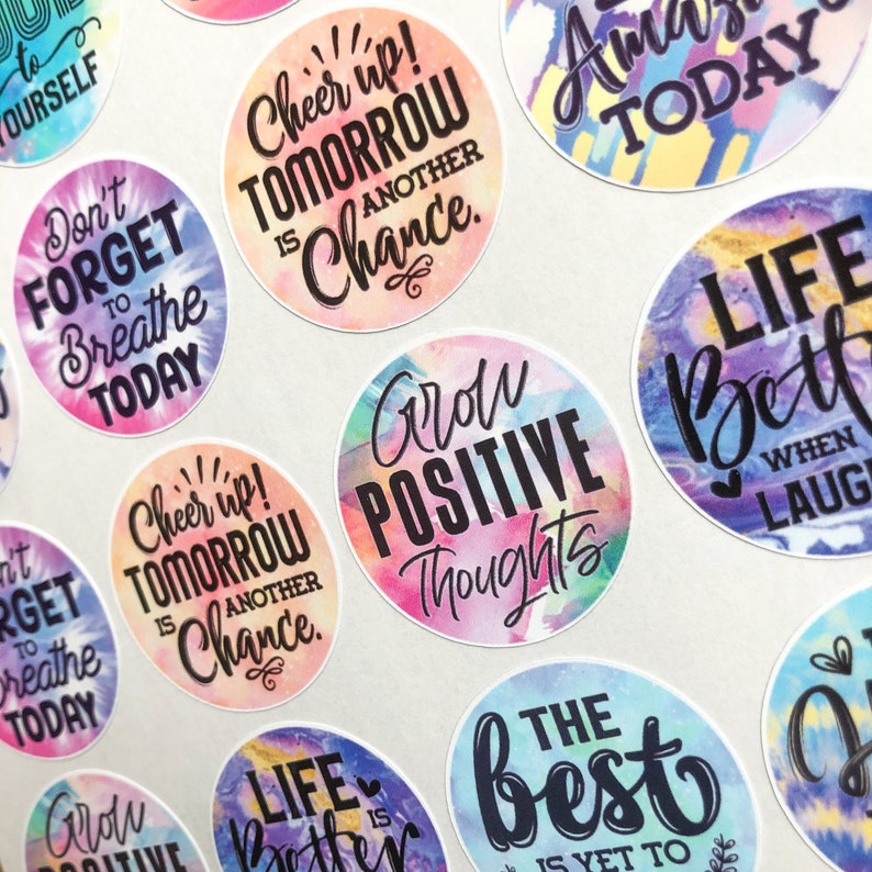 May include: Assortment of colorful round stickers with motivational quotes. The stickers feature watercolor-like backgrounds with black text. Some of the quotes include "Cheer up! Tomorrow is another chance", "Grow Positive Thoughts", "Life is Better When You Laugh", and "The Best is Yet to Come".
