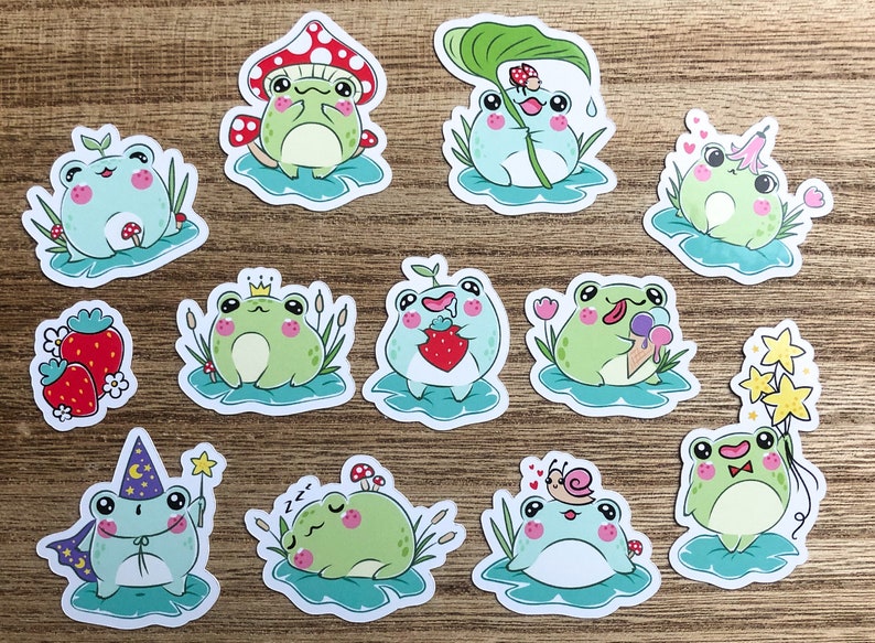 May include: A set of 12 frog stickers with various designs. The frogs are green and blue with different expressions and accessories. Some frogs are wearing crowns, eating strawberries, holding ice cream cones, or sleeping. The stickers are perfect for adding a touch of whimsy to journals, laptops, water bottles, and more.