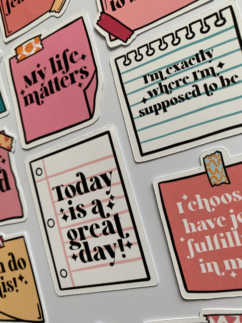 K&ouml;nnte beinhalten: Ein Set bunter Sticker mit positiven Affirmationen. Die Sticker zeigen S&auml;tze wie "Mein Leben z&auml;hlt", "Heute ist ein gro&szlig;artiger Tag!" und "Ich bin genau da, wo ich sein soll".