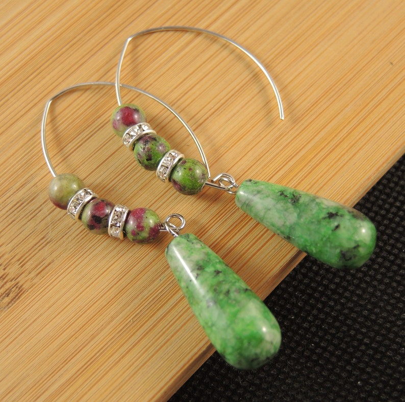 Peut inclure: Une paire de boucles d'oreilles cr&eacute;oles en argent avec des perles de pierres pr&eacute;cieuses vertes et roses et un pendentif en forme de larme en pierre pr&eacute;cieuse verte.