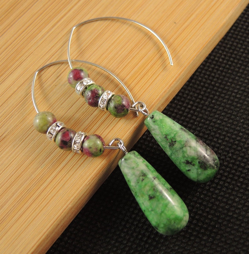 Peut inclure: Une paire de boucles d'oreilles cr&eacute;oles en argent avec des perles de pierres pr&eacute;cieuses vertes et roses et un pendentif en forme de larme en pierre pr&eacute;cieuse verte.
