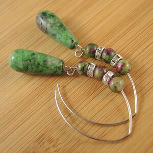 Peut inclure: Une paire de boucles d'oreilles en pierres pr&eacute;cieuses vertes et roses avec des cercles argent&eacute;s et des accents de strass transparents.