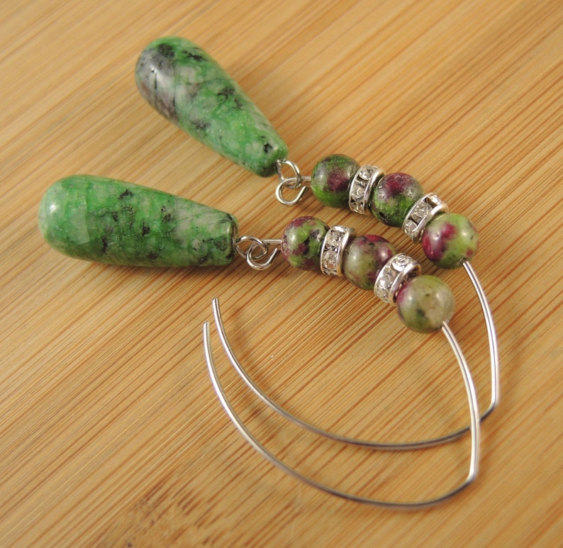Peut inclure: Une paire de boucles d'oreilles en pierres pr&eacute;cieuses vertes et roses avec des cercles argent&eacute;s et des accents de strass transparents.