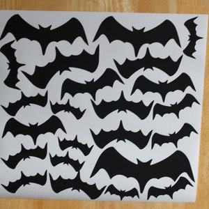 May include: A sheet of black bat cutouts on a white background. The bats are of various sizes and shapes.