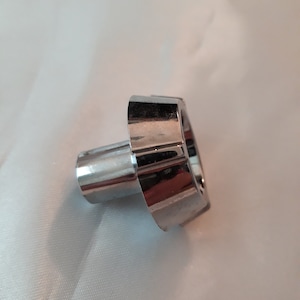 May include: A chrome-plated metal knob with a fluted edge and a round shaft.
