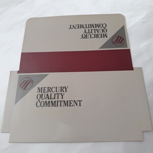 May include: A white envelope with a red stripe and a gray Mercury logo. The text "Mercury Quality Commitment" is printed on the envelope.