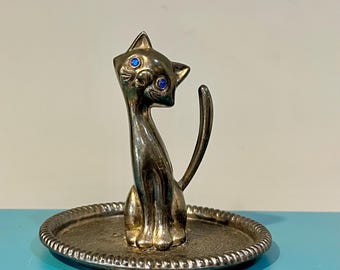 silver tone metal cat tail ring holder with blue rhinestone eyes.
