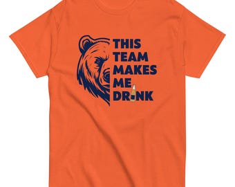 Może przedstawiać: Pomarańczowy T-shirt z grafiką niebieskiego niedźwiedzia i tekstem "This team makes me drink" z grafiką butelki piwa.