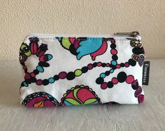 May include: White zippered pouch with a colorful beaded pattern and the text "Finlayson" on the side.