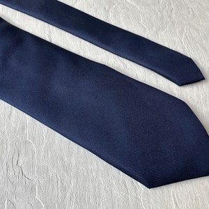 May include: A dark blue silk necktie with a subtle texture.