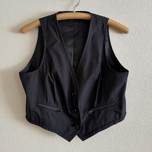 May include: A black sleeveless vest with a zipper closure and a button down front.