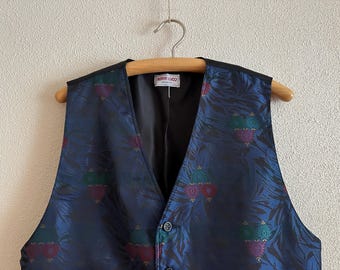 May include: A blue patterned vest with a black lining and a single button closure. The vest has a label that reads "GIANNI LACOSTE".